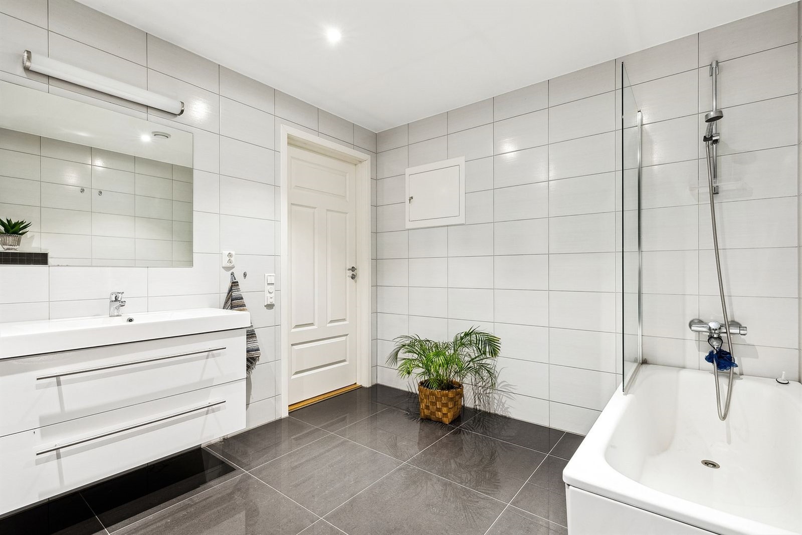 Bad/vaskerom i u.etg. Rommet er stort, med pene fliser og badekar. Varme i gulvene. Galleribilde