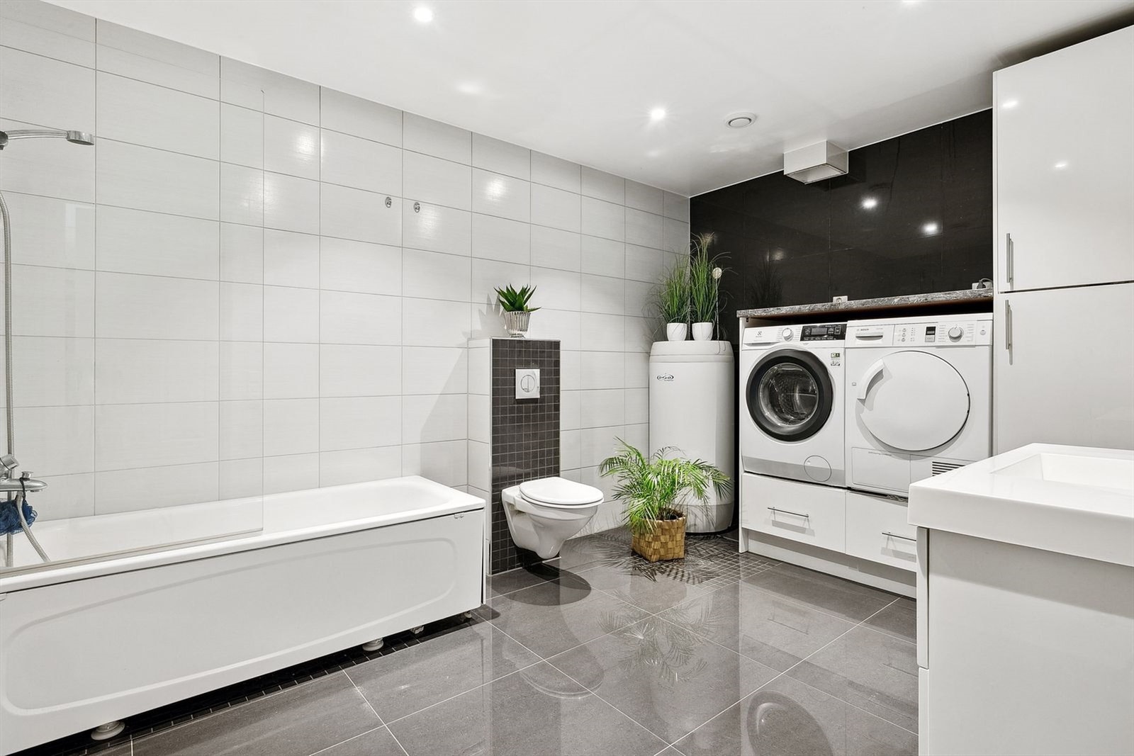 Bad/vaskerom i u.etg. Rommet er stort, med pene fliser og badekar. Varme i gulvene. Galleribilde