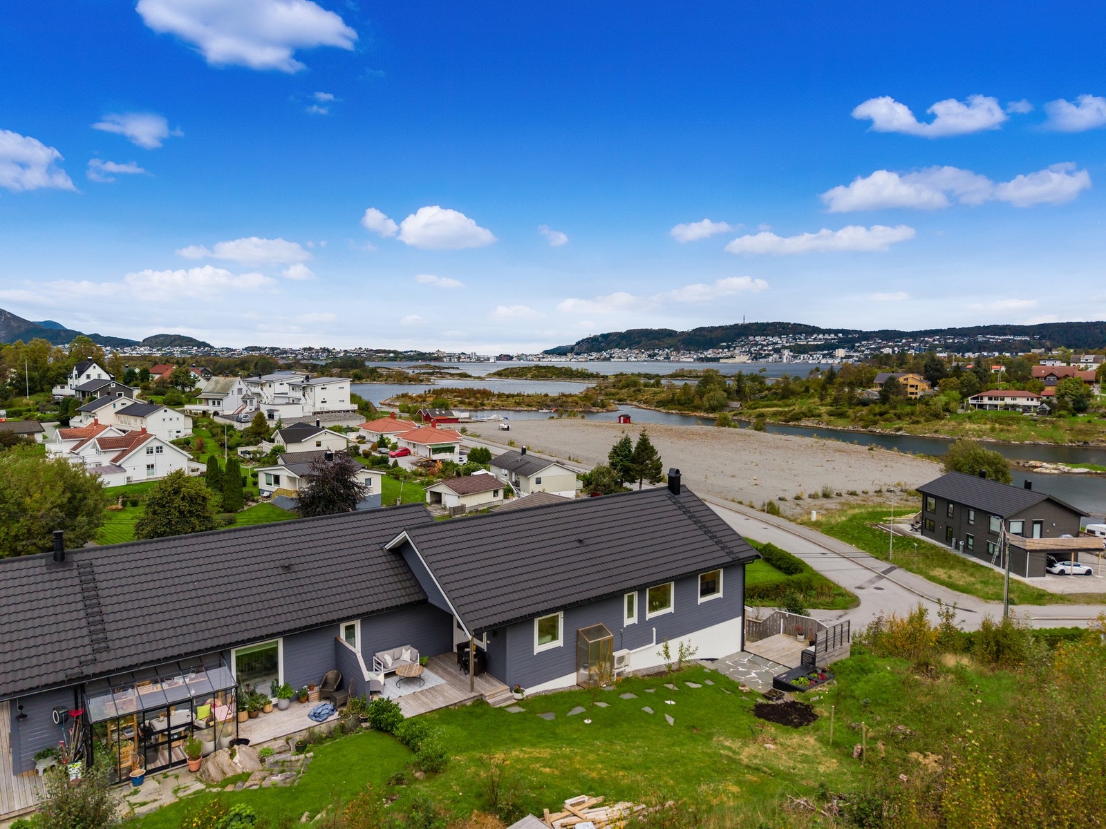 Uteområdet består av skjermet platting, hage med prydbusker og utekjøkken Galleribilde