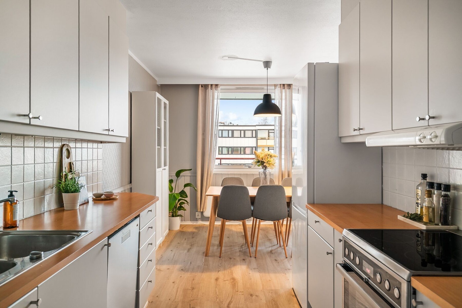 Lyst og fint kjøkken med praktisk utforming og gode arbeidsflater. Kjøkkenet har rikelig med skap- og benkeplass. Galleribilde