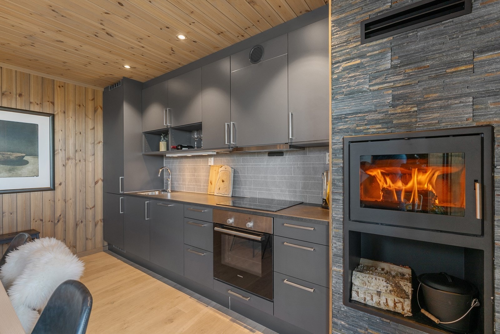 Kjøkkenet har integrerte hvitevarer som komfyr, platetopp, oppvaskmaskin og kjøl-/fryseskap Galleribilde