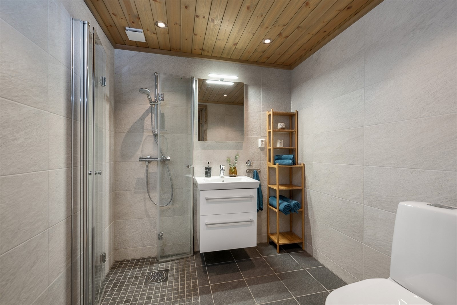 Baderommet er lyst og flislagt med elektriske varmekabler i gulv og innfelte downlights i himling Galleribilde