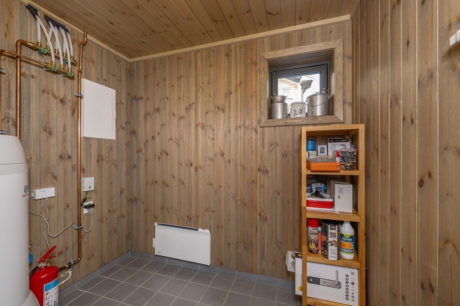 Utvendig bod har fliser på gulv, panel på vegger og plass til oppbevaring av sommer- og vinterutstyr Galleribilde