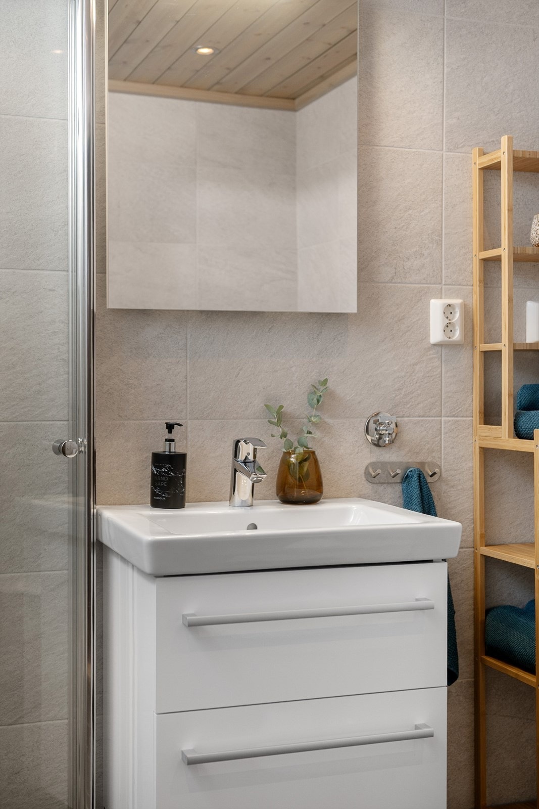 Badet består av servantinnredning, dusjsone med innfellbare dusjdører, toalett og opplegg til vaskemaskin Galleribilde