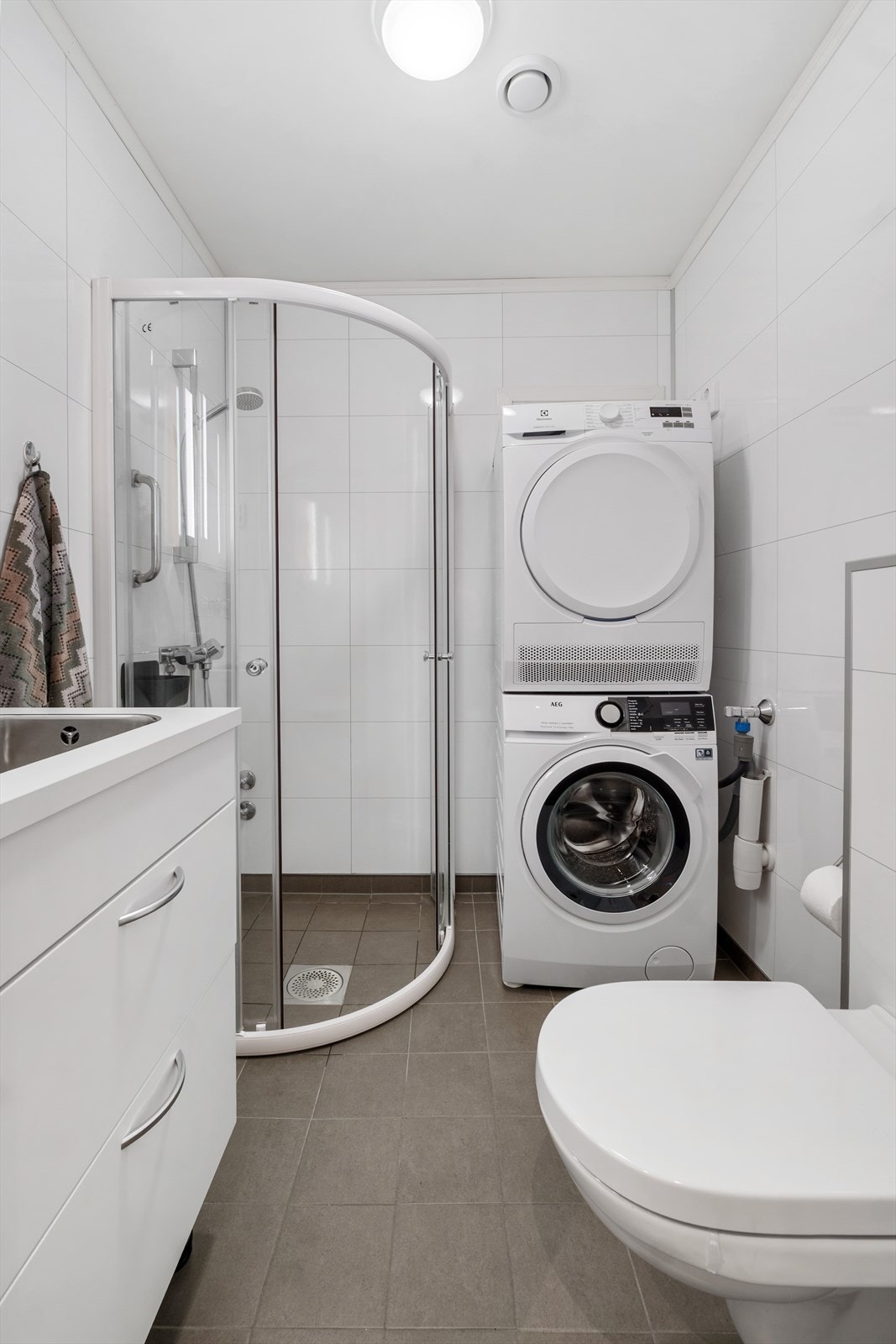 Badet har innredning med nedfelt servant, veggmontert toalett og dusjvegger. Galleribilde