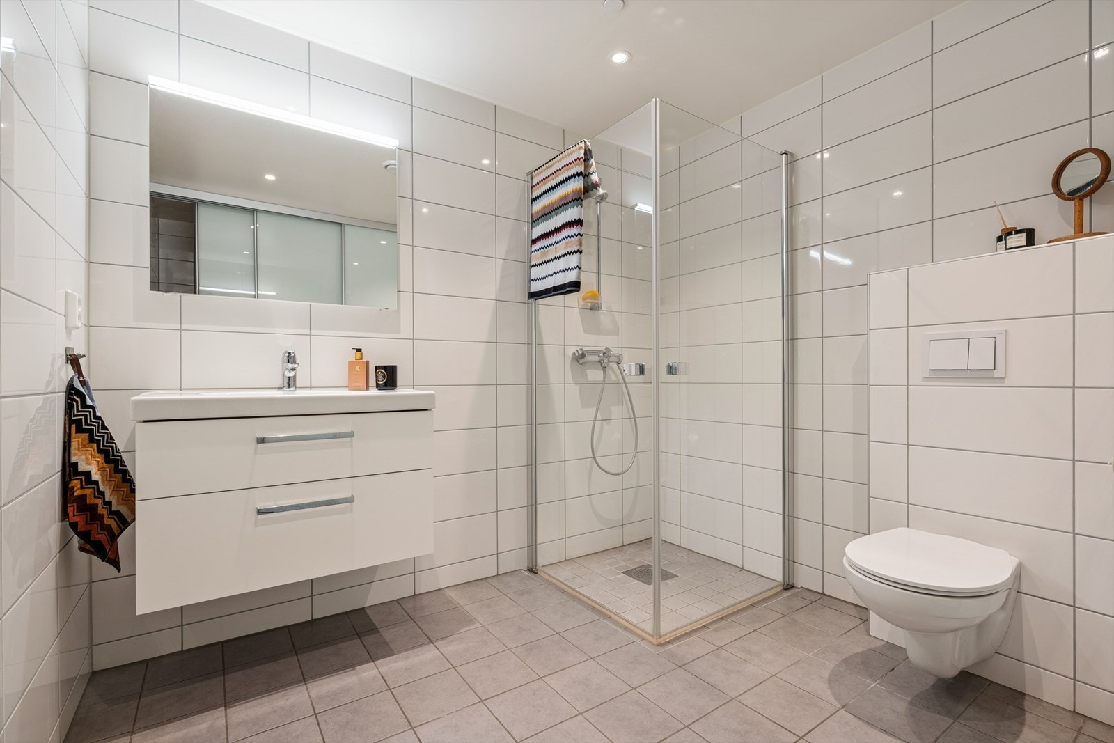 Delikat bad med tidløse fliser, vegghengt WC og stilren innredning. Galleribilde