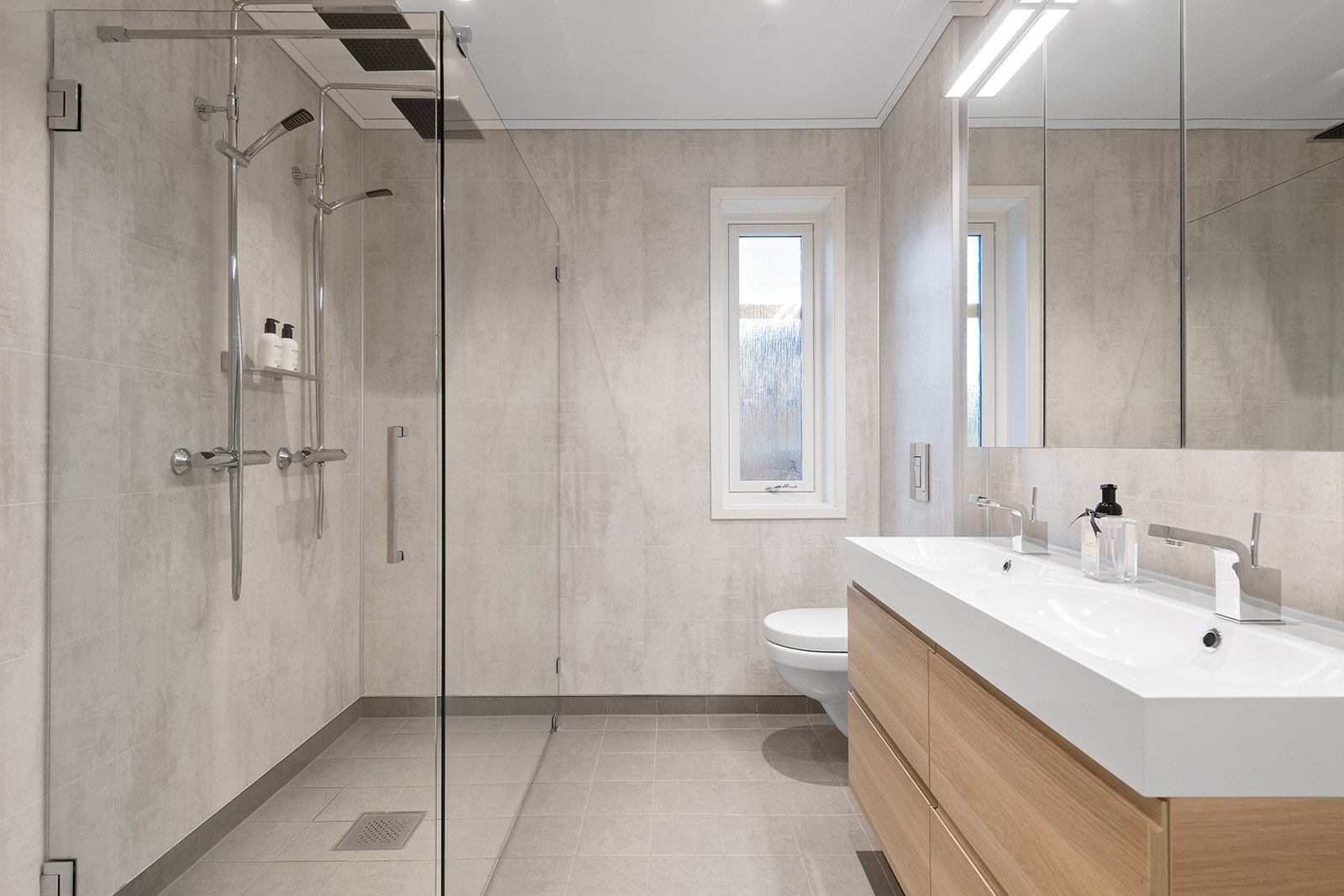 Bad i 2. etasje. Romslig med dobbel dusj og god skapplass. Baderomsplanel på vegger og flis på gulv med varme. Galleribilde