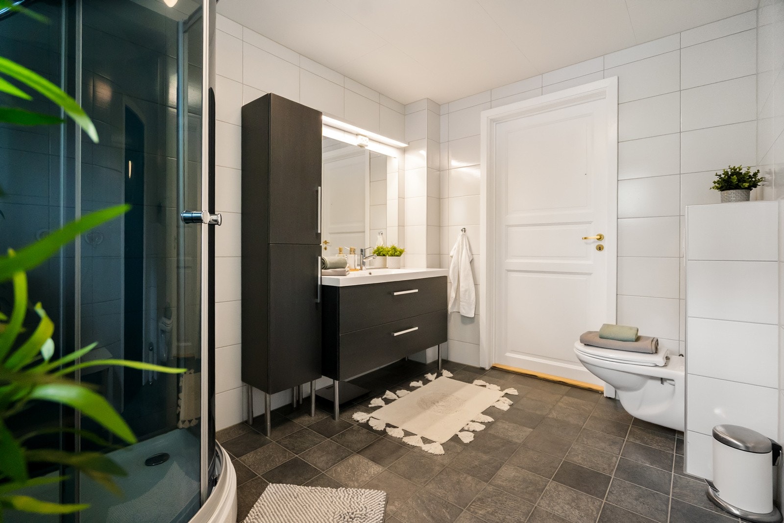 Badet er innredet med servantinnredning, dusjkabinett og toalett. Galleribilde