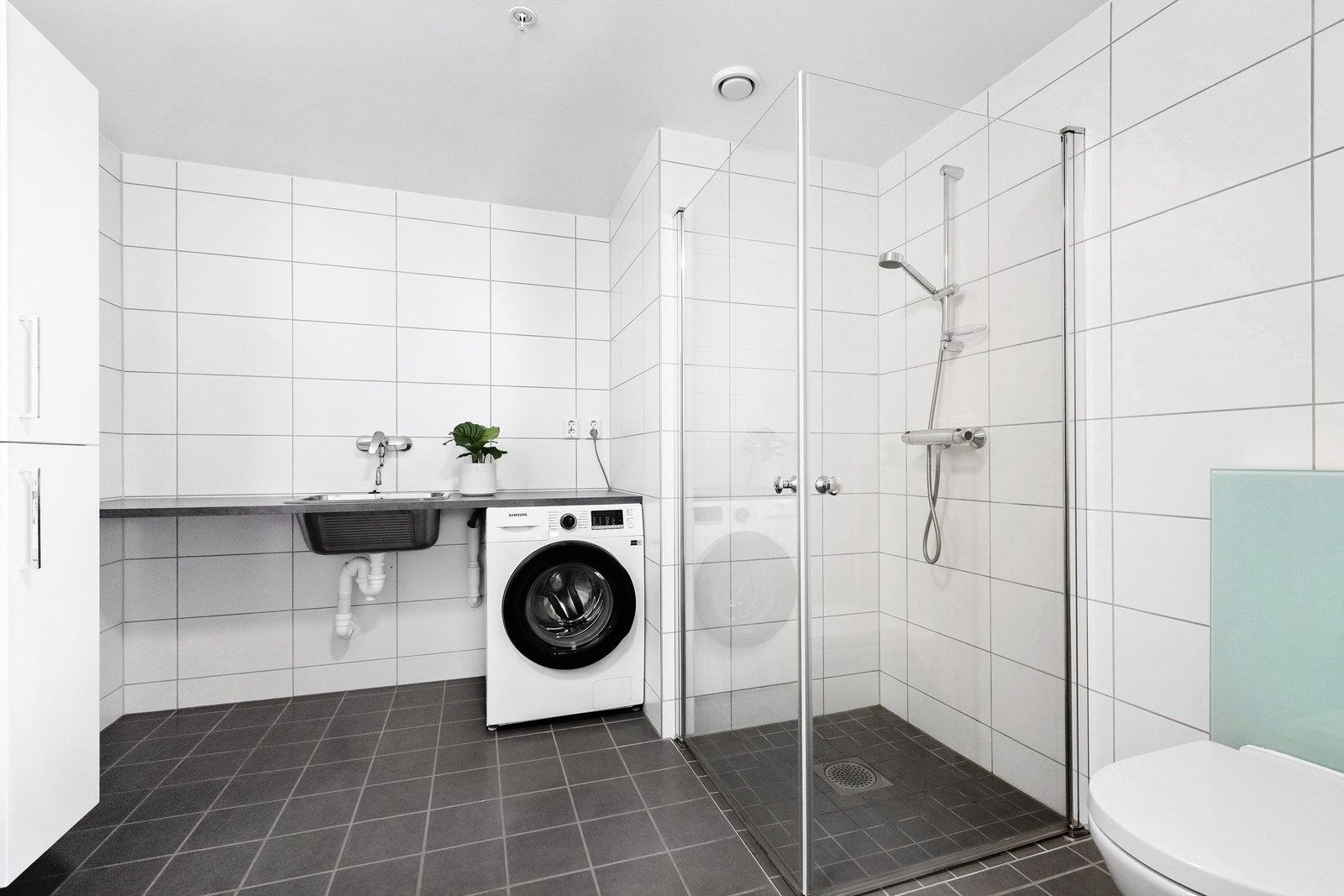 Bad 2. Laminert benkeplate med utslagsvask i metall. Dusjhjørne. Opplegg for vaskemaskin. Galleribilde