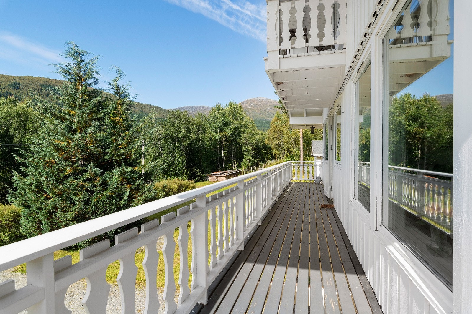 Her ser vi hvordan verandaen går videre foran fremsiden av huset. Galleribilde