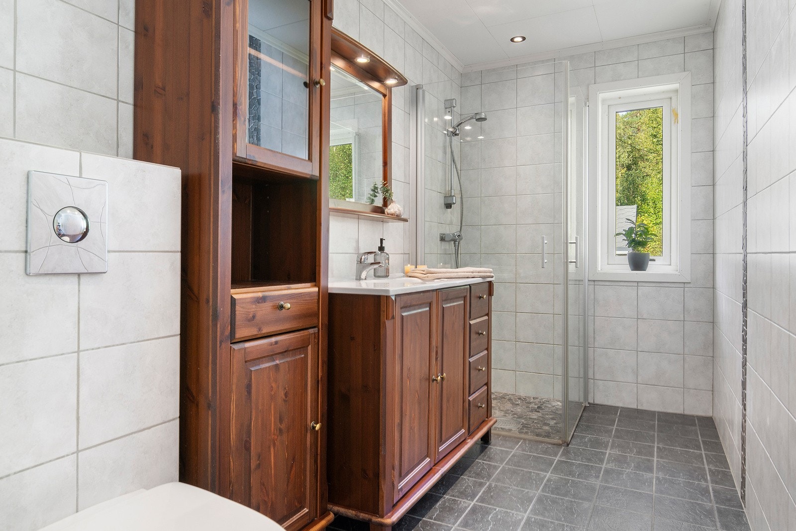 Badet i denne etasjen er helfliset og har dusjhjørne med innfellbare glassvegger. Galleribilde