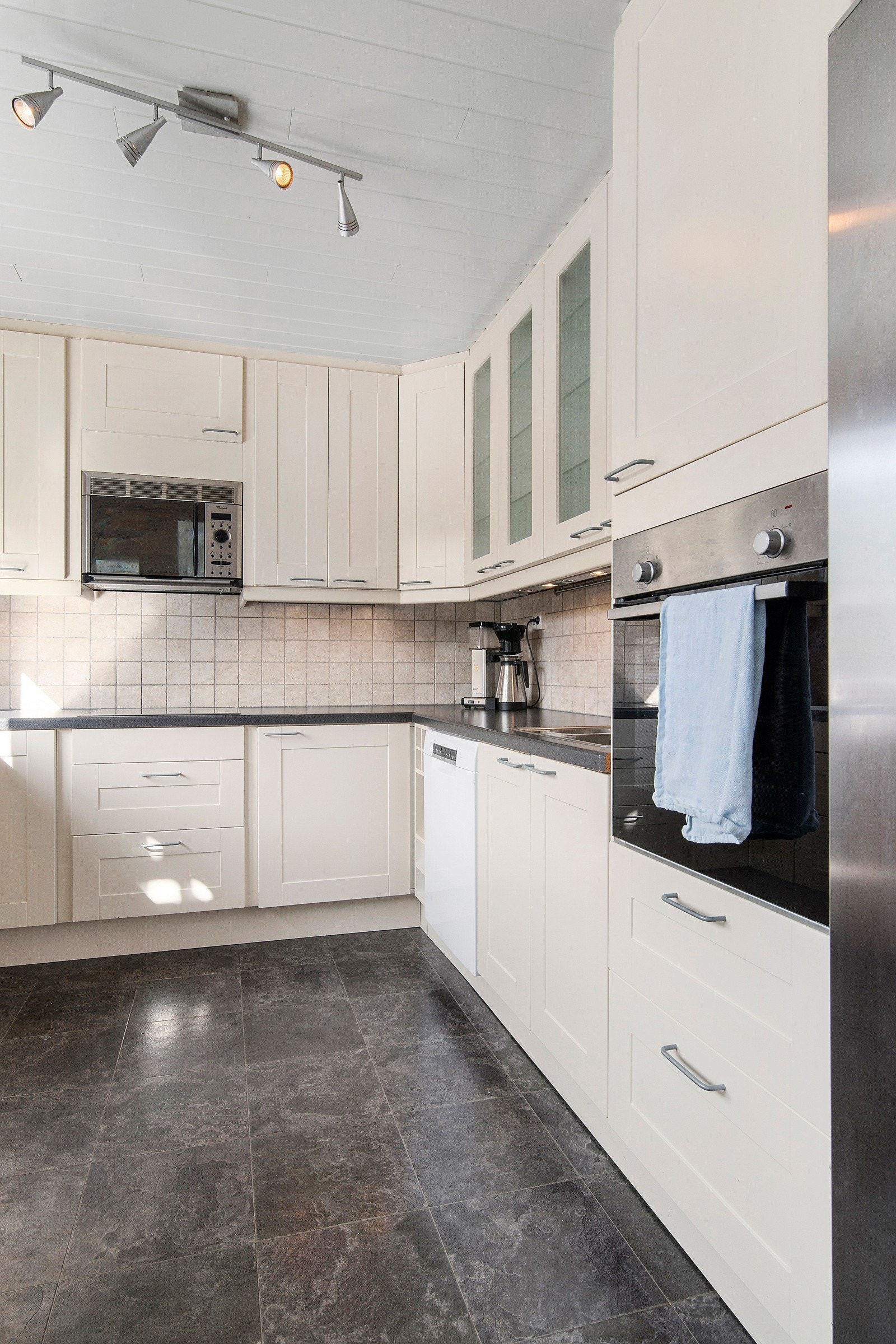 Mellom overskap og benkeplate er det fliser. Galleribilde