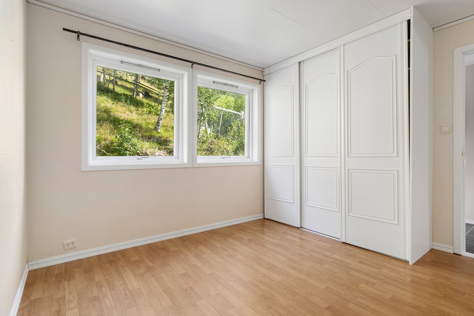 Det er et soverom i hovedetasjen med plassbygd skyvedørsgarderobe. Galleribilde