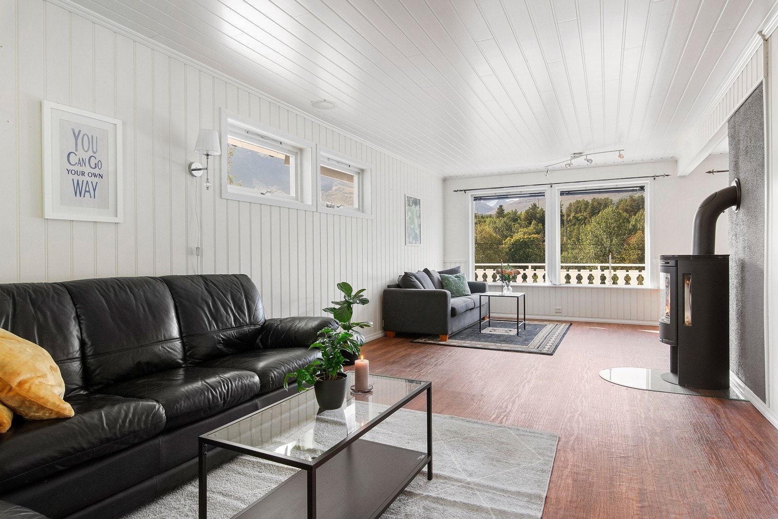 Stuen er i vinkel, noe som gir god plass til sofagruppe, gode lenestoler foran peisen - Galleribilde