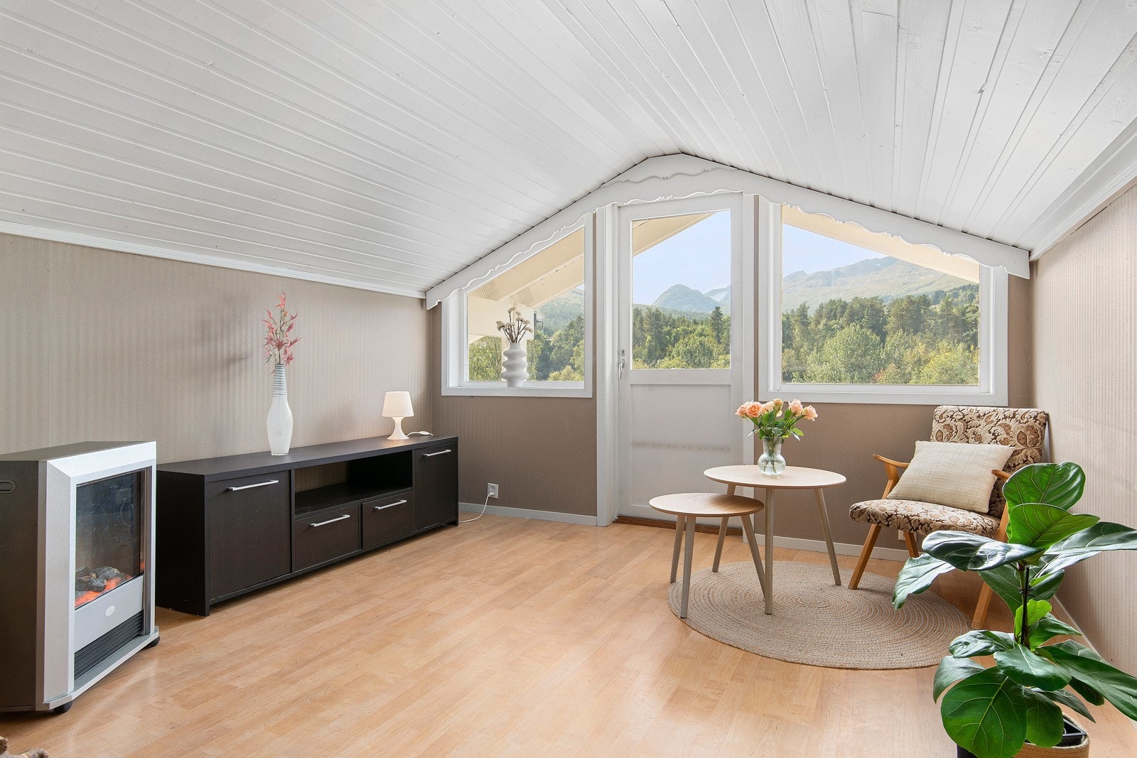 Det er laminat på gulvet, malt panel i himlingen og malte tapetserte flater på veggene. Galleribilde