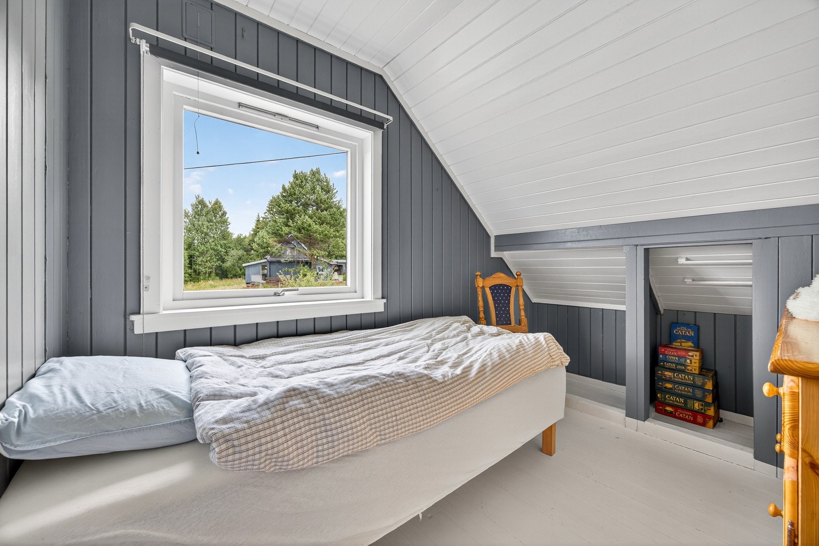 Soverom 2 har malt panel på veggflater, sjarmerende skråtak og malte heltre gulvbord. Galleribilde