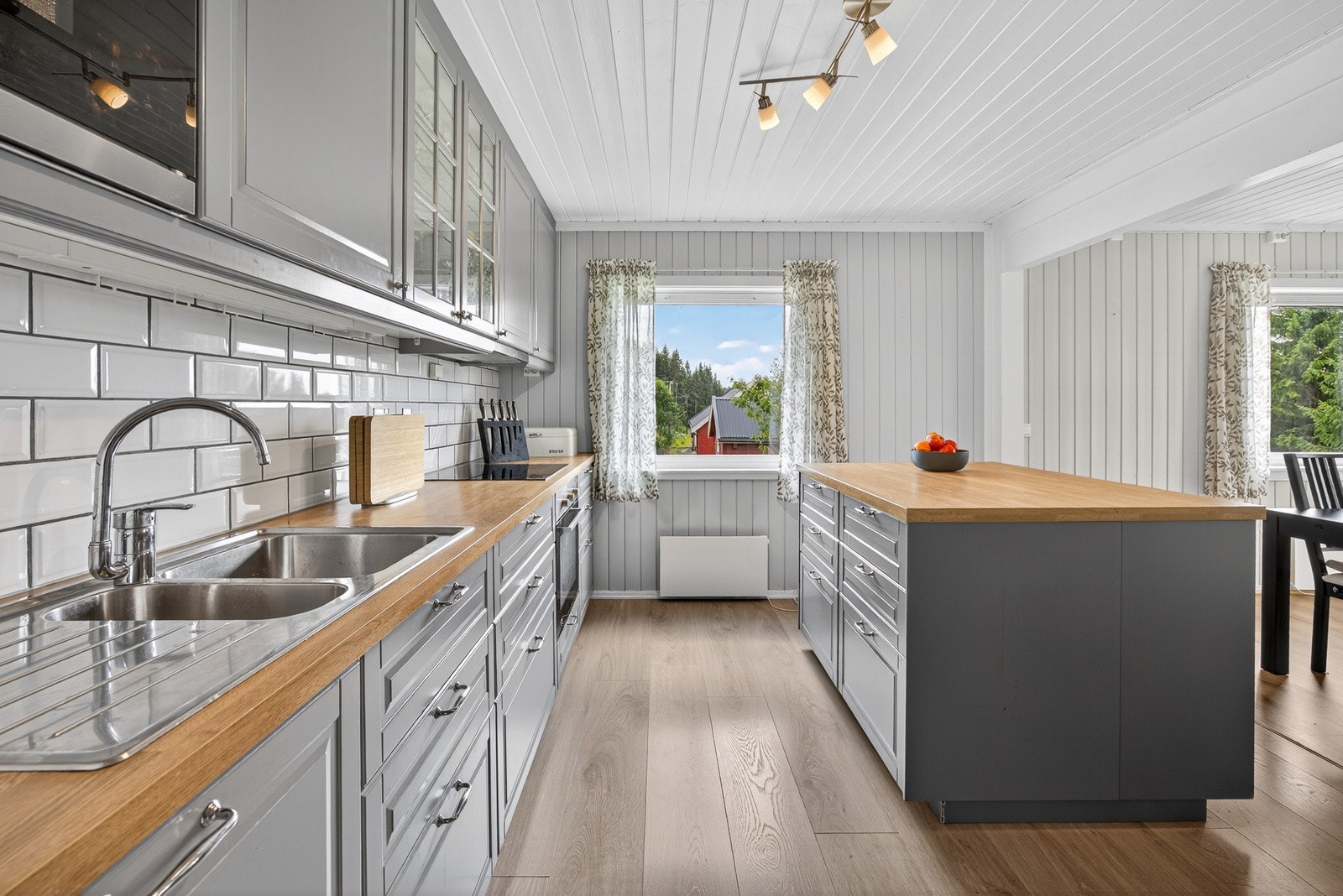 Kjøkken og stue ligger i en åpen og gjennomgående løsning som skaper en romslig og sosial sone, perfekt for både hverdagsliv og selskap. Kjøkkenet er fra IKEA og ble installert i 2016. Galleribilde