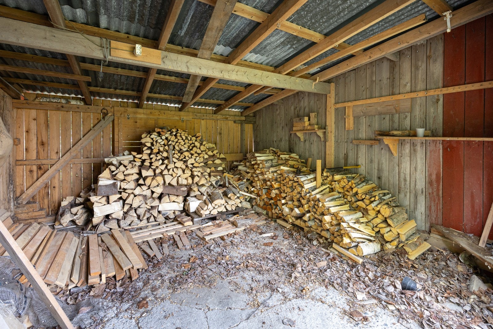 Frittstående garasje med vedskjul og slakterom. Selger informerer at veden er produsert lokalt og følger med ved salget av småbruket. Galleribilde