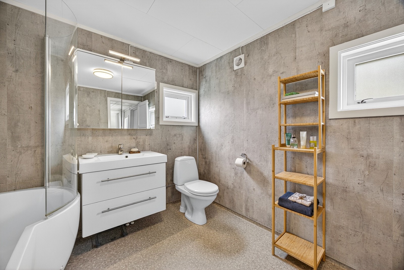 Badet ble oppgradert i 2016 og fremstår som moderne og funksjonelt. Det er baderomsplater på veggflater og belegg med gulvvarme på gulv. Galleribilde