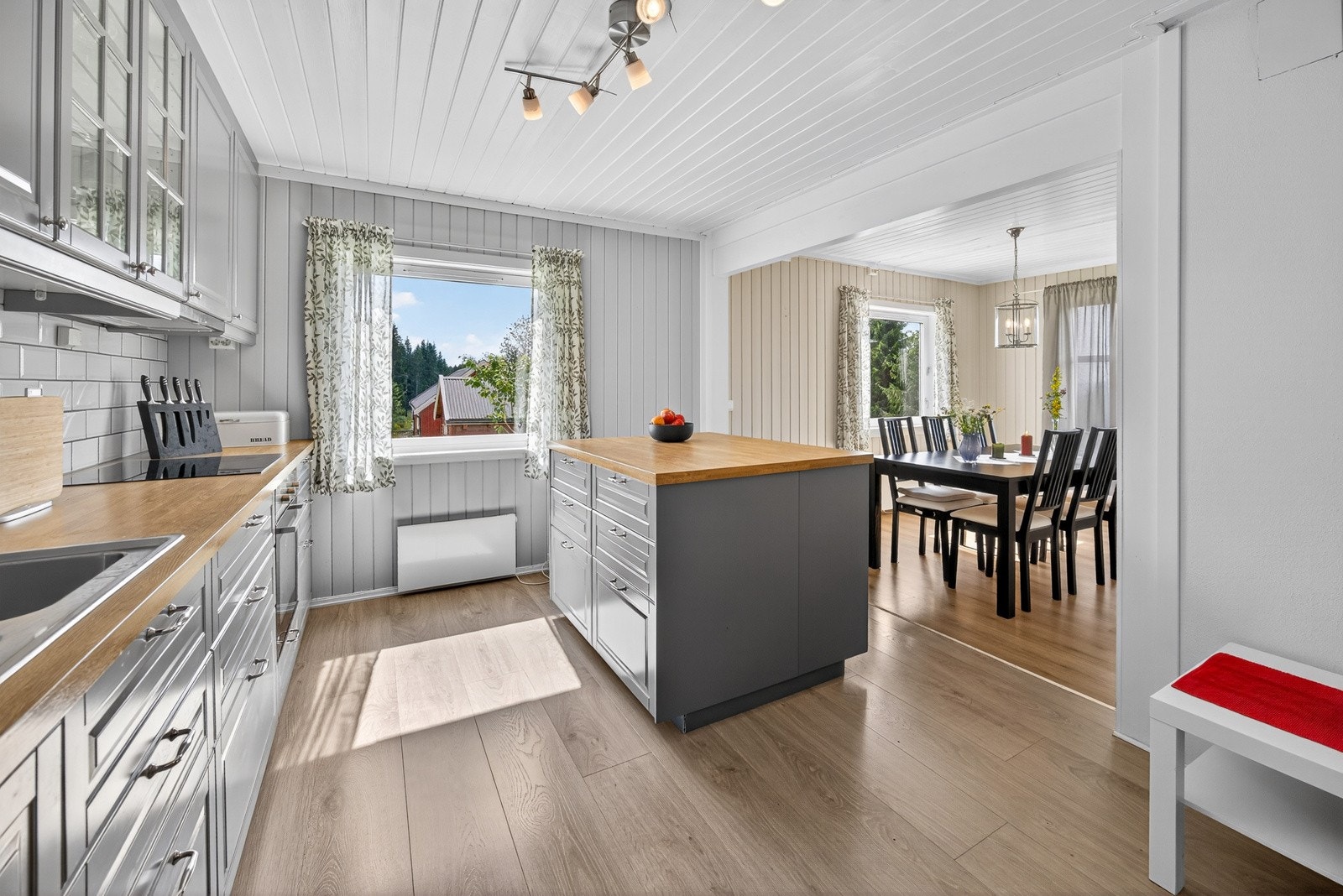 Innredningen har profilerte fronter, laminat benkeplate og en praktisk kjøkkenøy som gir ekstra arbeidsflate og oppbevaringsplass. Galleribilde