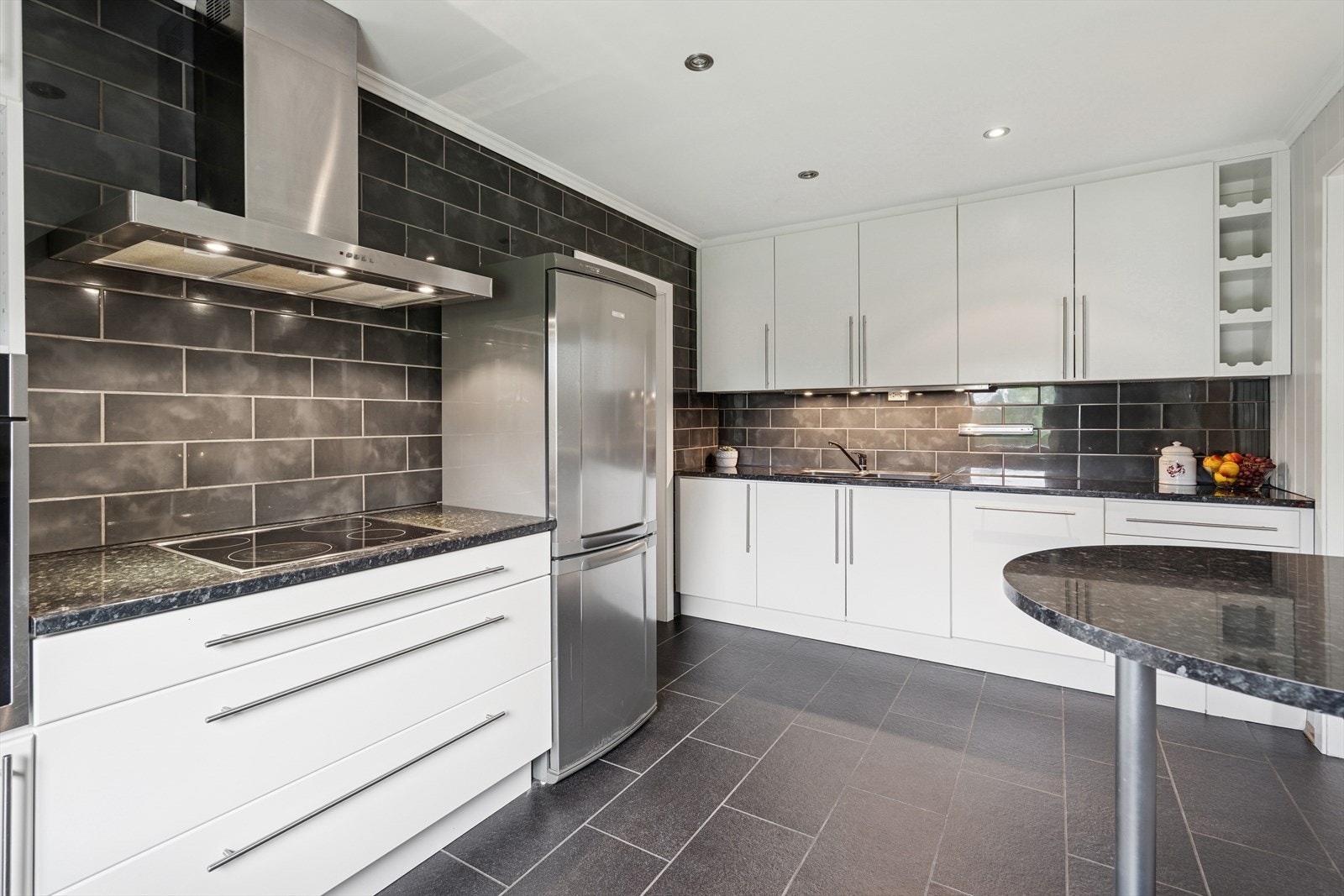 Kjøkkeninnredning er hvit og er fra 2009 med glatte fronter og benkeplate i laminat. Galleribilde