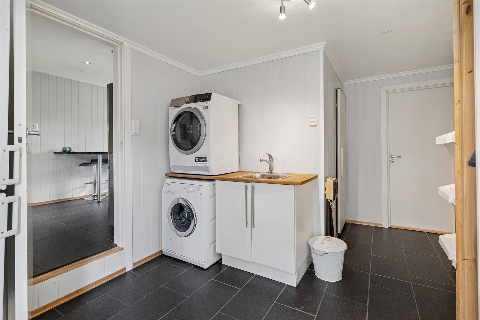 Vaskerom med innredning med vask og avsatt plass for vaskemaskin. Galleribilde