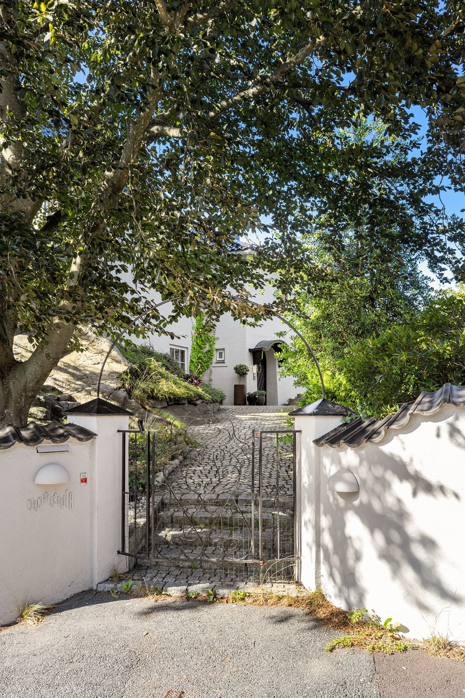 Innbydende inngangsparti med smijernsport og brosteinsbelagt sti Galleribilde