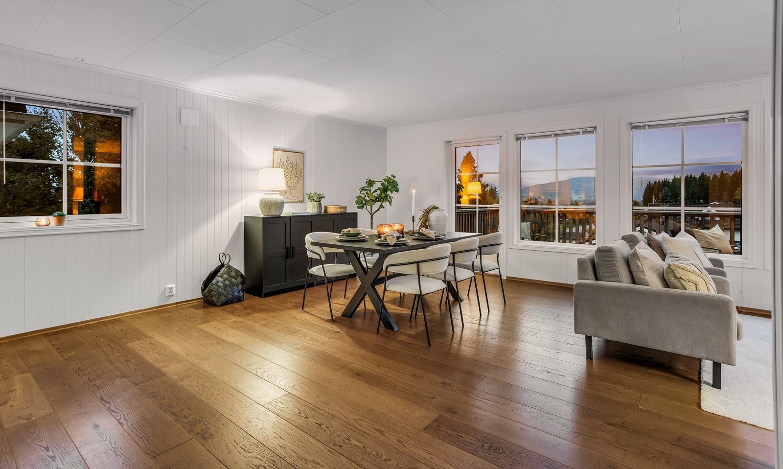 Stuen er et lyst og luftig rom med parkett på gulvet og store vindusflater. Galleribilde