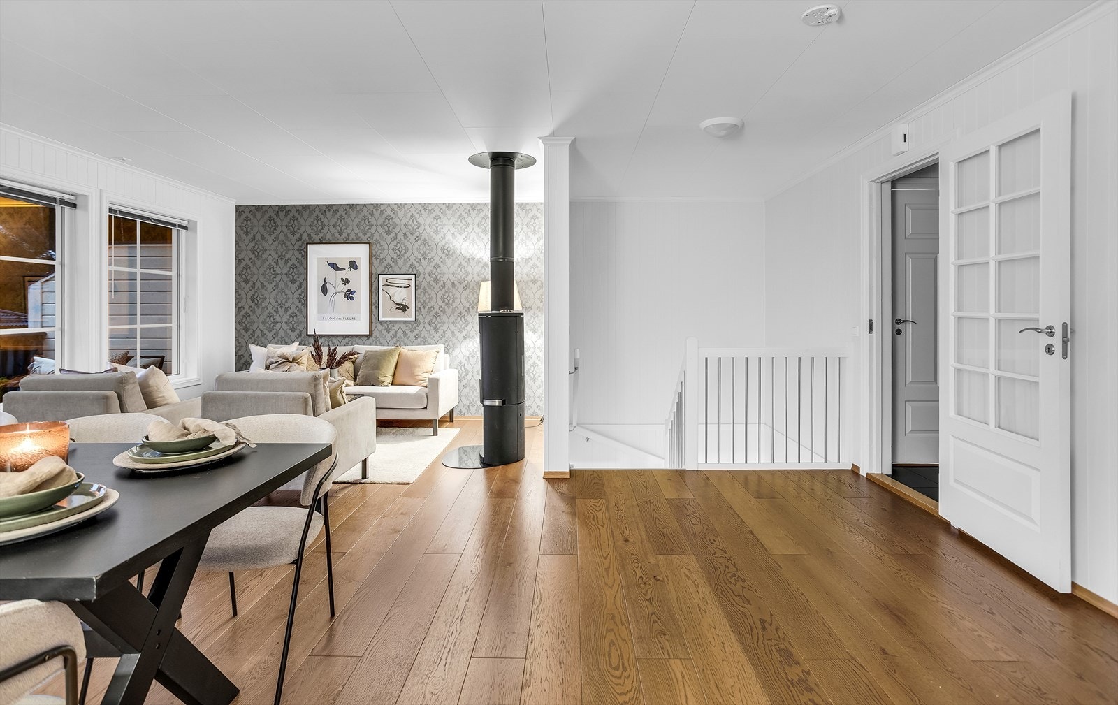 En dør med glassfelt skiller stuen fra gangen og slipper lys mellom rommene. Galleribilde