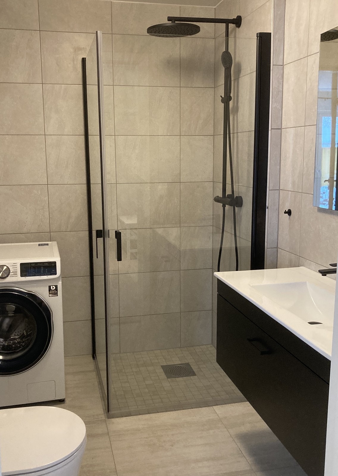 Pent flislagt bad med regndusj, vegghengt wc og servant m/innredning. Vaskemaskin følger med Galleribilde