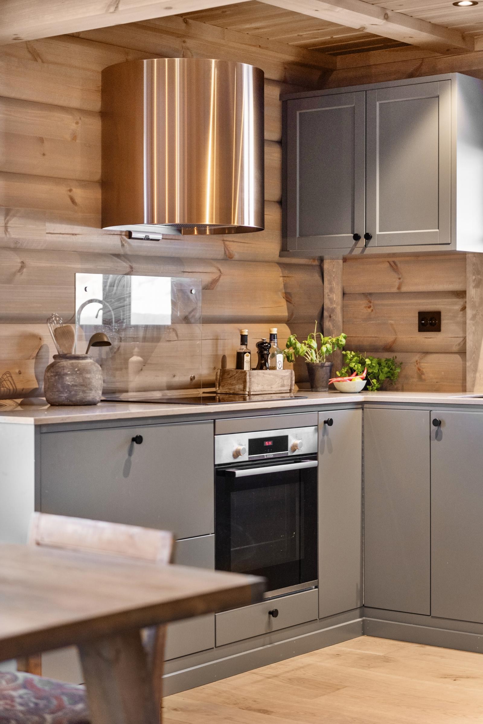 Kjøkkenet har flott innredning med glatte fronter, i en tidsriktig fargenyanse og benkeplate av sten. Galleribilde