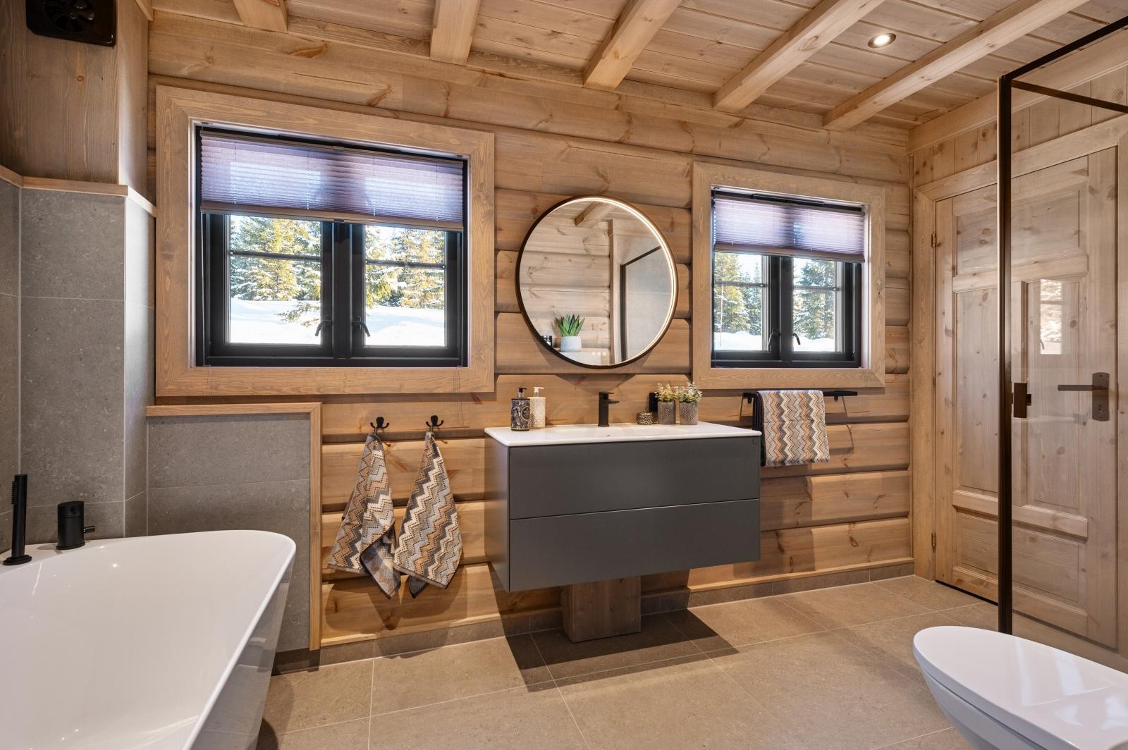 Badet har dusjhjørne, badekar og flislagt gulv med varmekabler. Fra dette badet har man inngang til et praktisk vaskerom/teknisk rom. Galleribilde