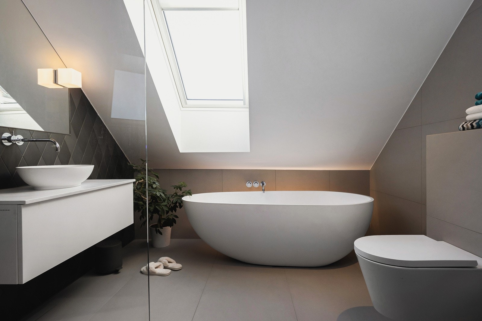 Lekkert baderom som er utstyrt med bl.a. gulvvarme, Copenhagen Hammershus badekar i hvit matt kompositt, Kartell vegghengt toalett, baderomsinnredning og servant fra Dansani. Galleribilde