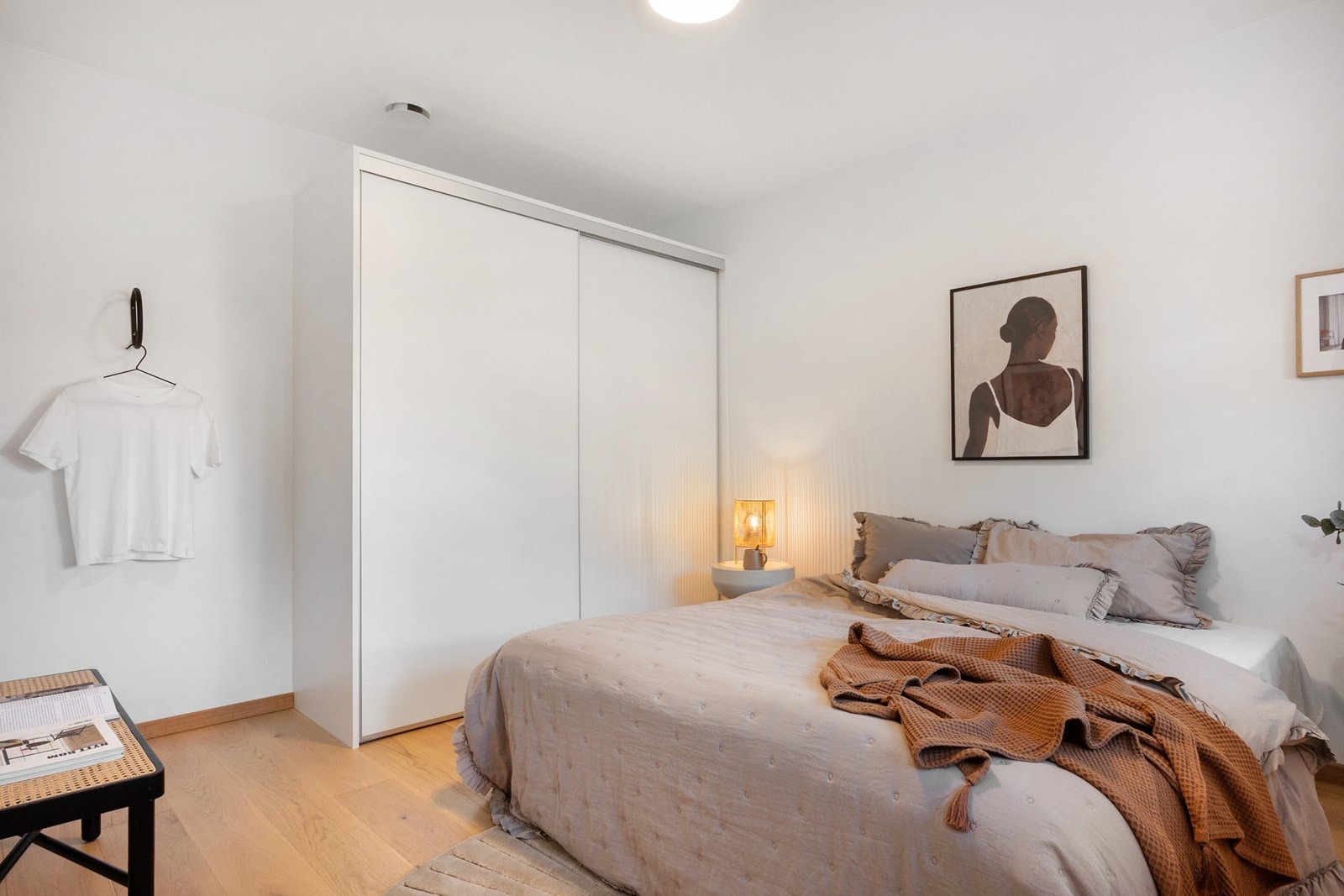 En stor skyvedørsgarderobe med hvite fronter gir rikelig med oppbevaringsplass. Galleribilde