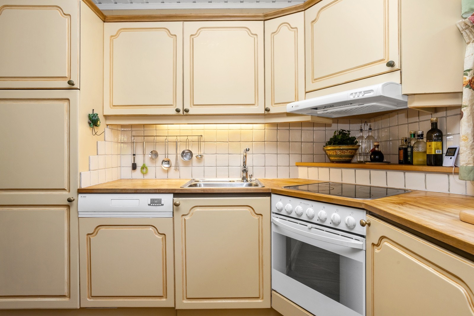 Kjøkkenet har profilert innredning, heltre benkeplate og fliser mellom benk og overskap. Galleribilde