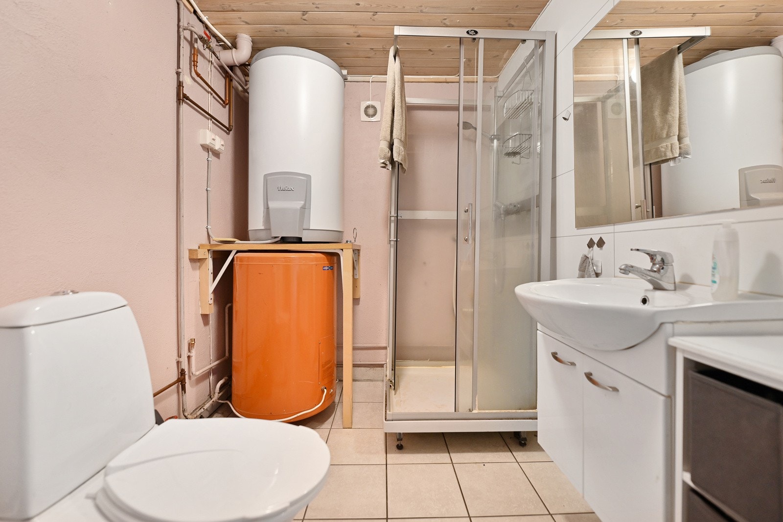 Badet har innredning med nedfelt servant, gulvfestet toalett, dusjkabinett og opplegg for vaskemaskin. Galleribilde