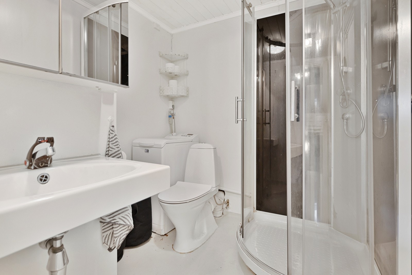 Badet i kjeller. Rommet har servant, gulvfestet toalett, dusjkabinett og opplegg for vaskemaskin. Galleribilde