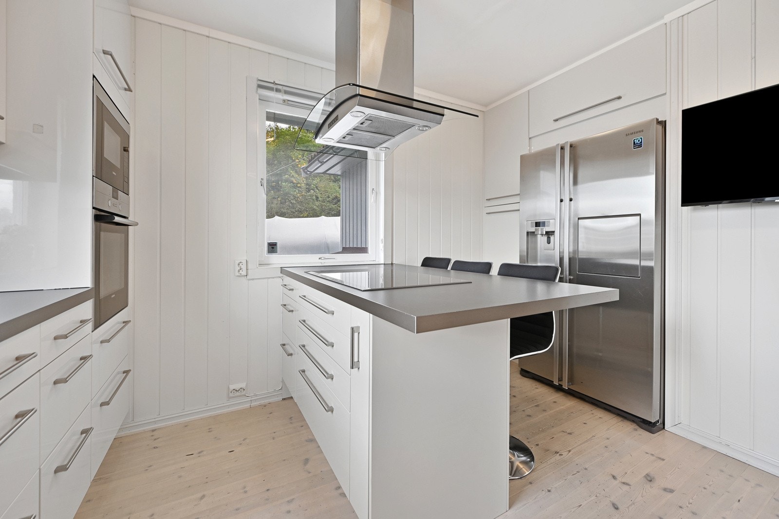 Kjøkkenet har slette fronter og laminat benkeplate. Integrert komfyr, induksjonstopp, mikrobølgeovn og oppvaskmaskin, frittstående kjøl/fryseskap. Galleribilde