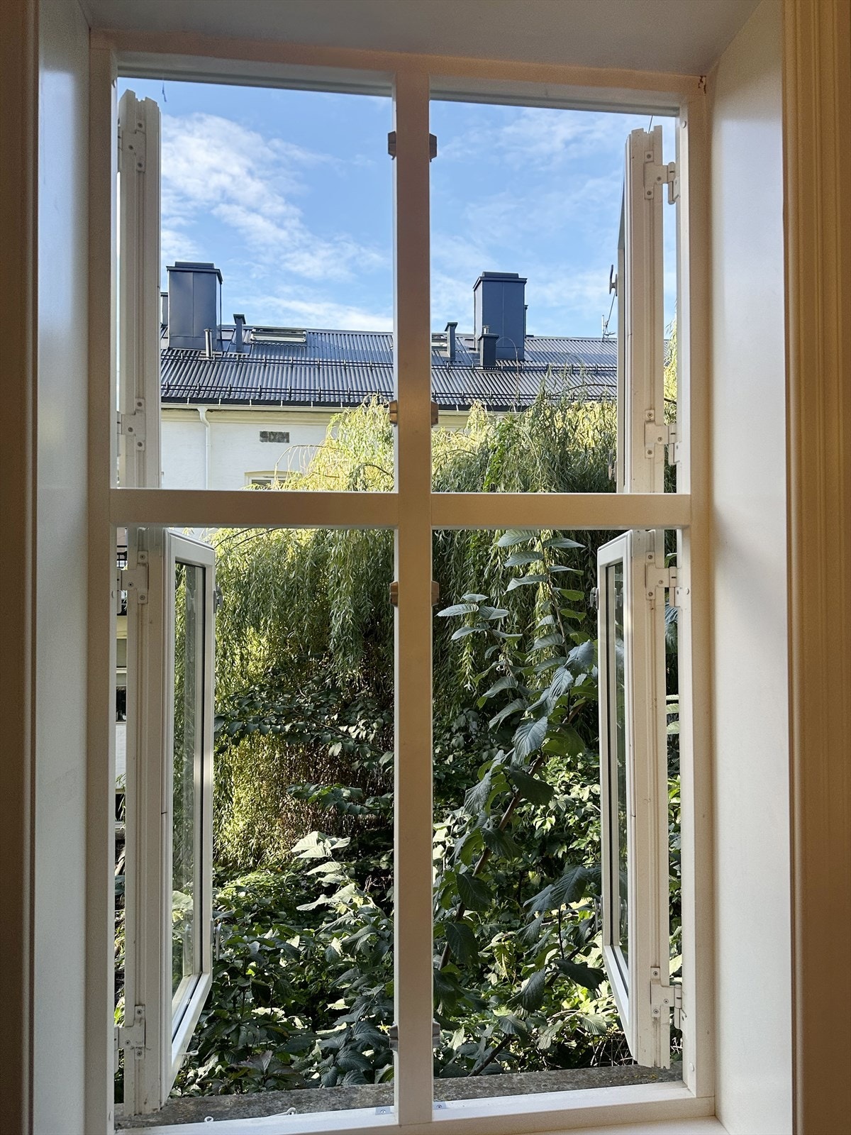 Frodig utsikt ut mot bakgård fra soverommet. Bildet er tatt av selger og er fra sommerstid. Galleribilde