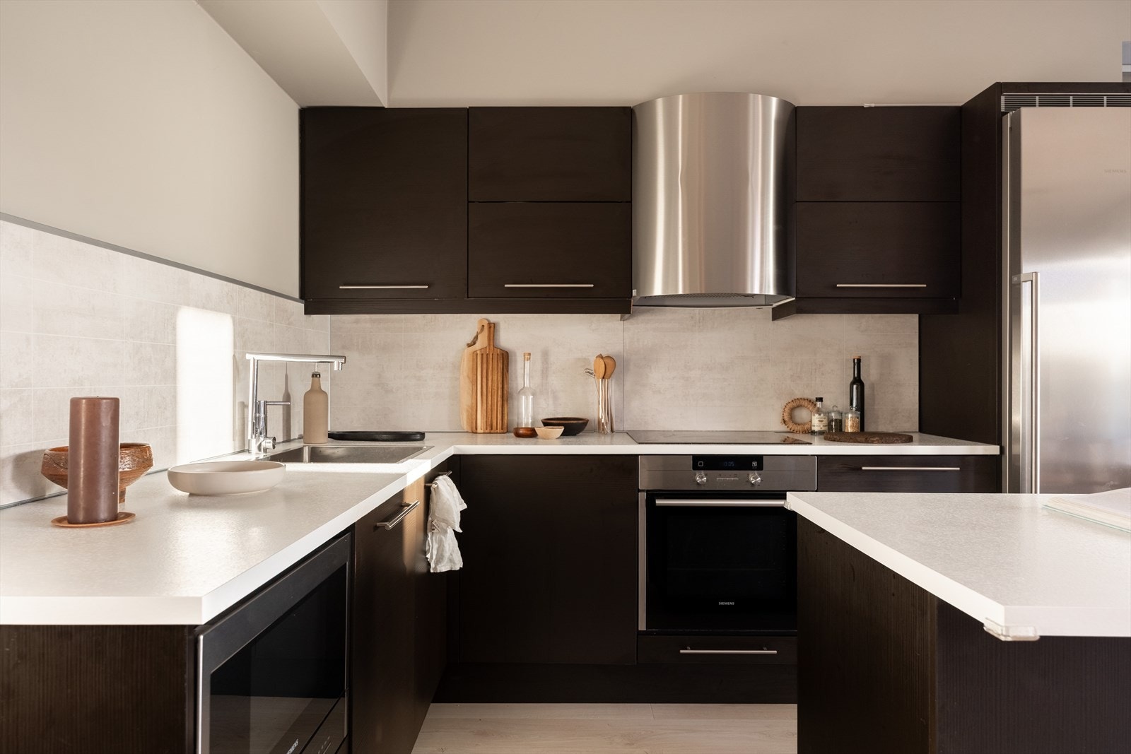 Kjøkkenet har moderne innredning med glatte fronter, slitsterk laminat benkeplate og hvitevarer som kjøleskap, oppvaskmaskin, platetopp og stekeovn. Galleribilde