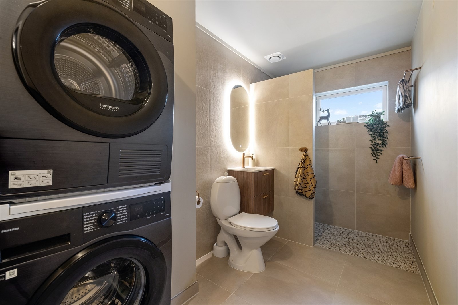 Boligen har et kombinert bad- og vaskerom som ble oppusset i 2025, som er er lokalisert i 2. etasje. Rommet har lyse 60 x 60 fliser på gulvet med varmekabler, og en kombinasjon av lyse 60 x 60 fliser på veggene og malte glatte flater. Galleribilde