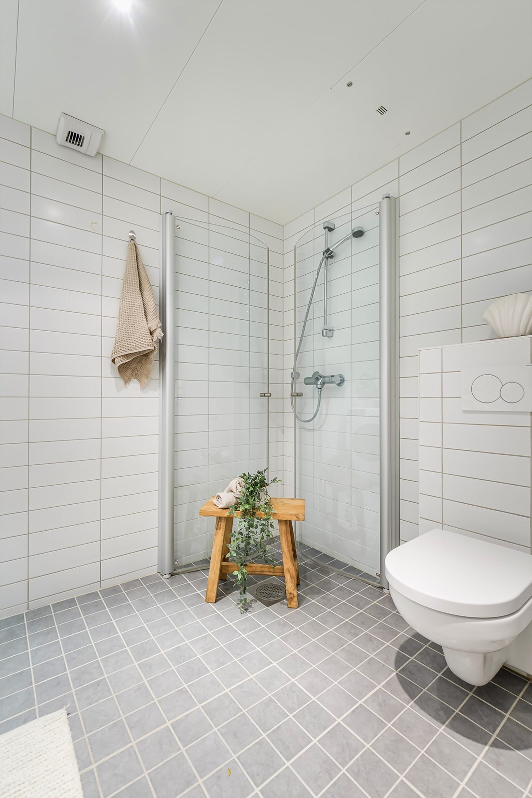 Dusjsone med innfellbare dusjdører og vegghengt toalett. Galleribilde