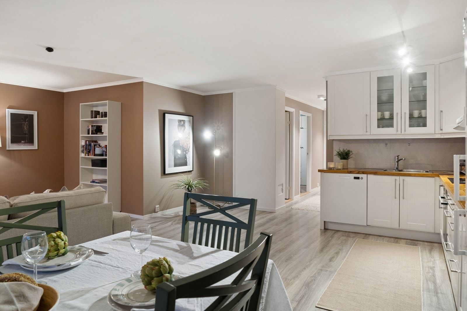 Rommet har en praktisk og sosial planløsning som kombinerer kjøkken, spiseplass og stue på en balansert måte. Galleribilde