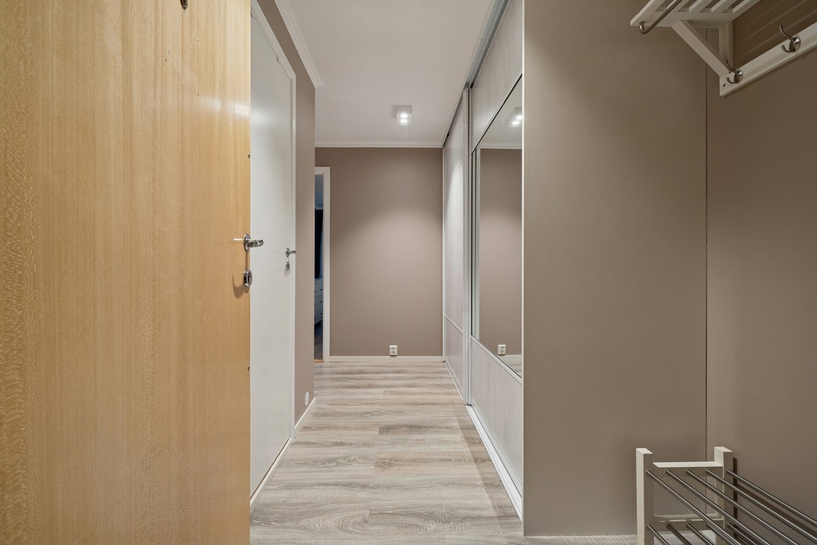 Velkommen inn! Lys og moderne gang med god oppbevaringsplass. Gangen har et stilrent og innbydende uttrykk med vegger i en beige tone som gir rommet en behagelig atmosfære. Galleribilde