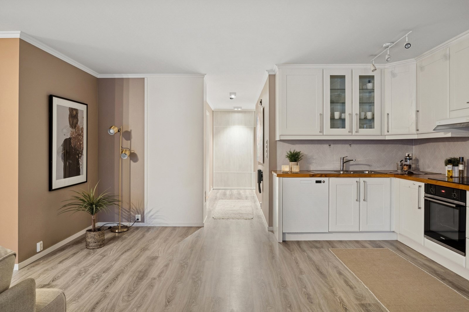 Lyst og innbydende oppholdsrom med åpen kjøkkenløsning. Rommet har et moderne og harmonisk uttrykk Galleribilde