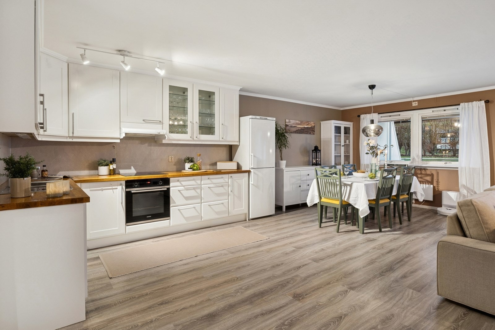 Romslig kjøkken med godt med oppbevaring. Løsningen gir god plass til både matlaging og hyggelige måltider. Spiseplassen ligger ved vinduet, som gir rikelig med naturlig lys og utsikt. Galleribilde