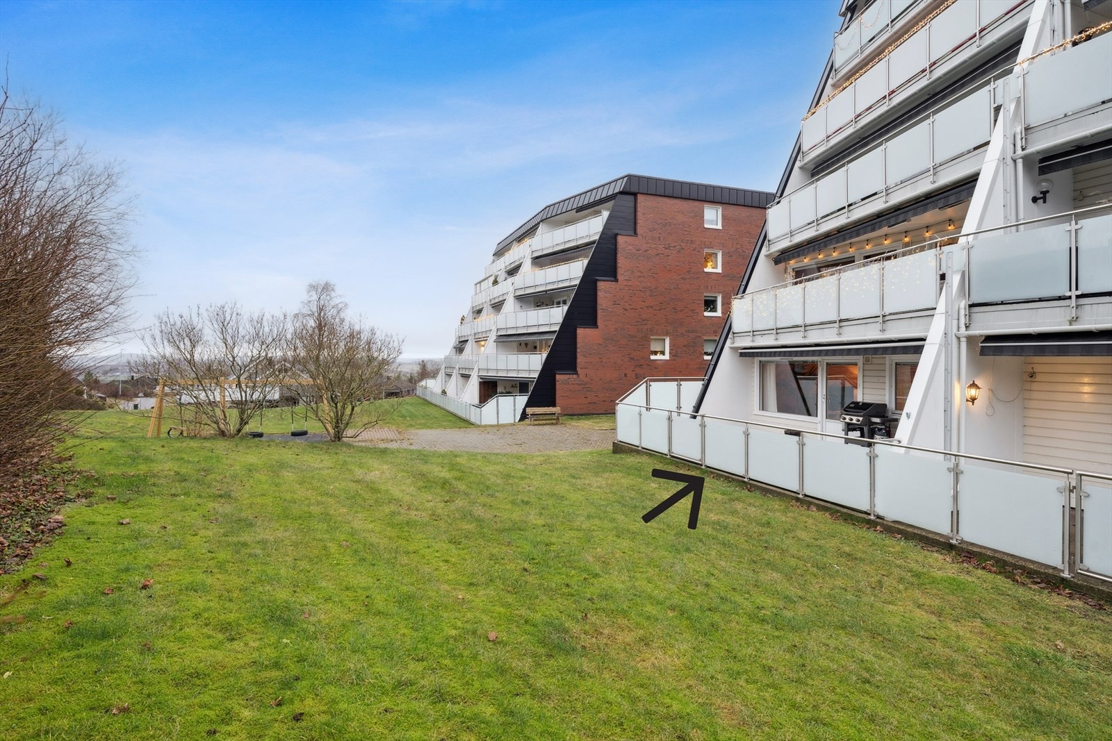 Boligen byr på en solrik og romslig terrasse med adkomst til frodig fellesareal med lekeplass. Beplanting skaper et lun atmosfære Galleribilde