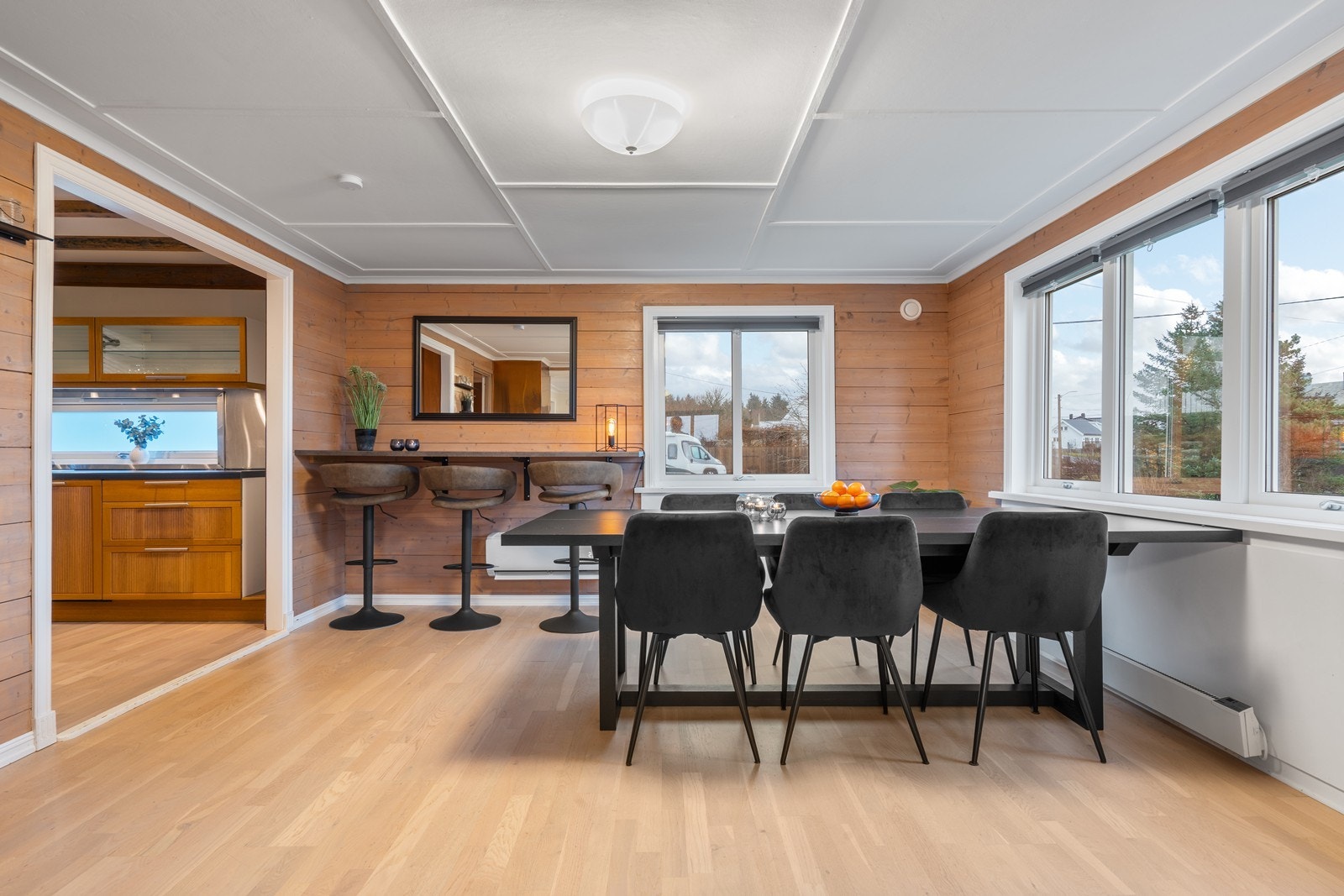Spisestue med bevarte tømmervegger som gir en varm, nostalgisk ramme, kombinert med moderne overflater og åpen løsning mot kjøkken. Galleribilde