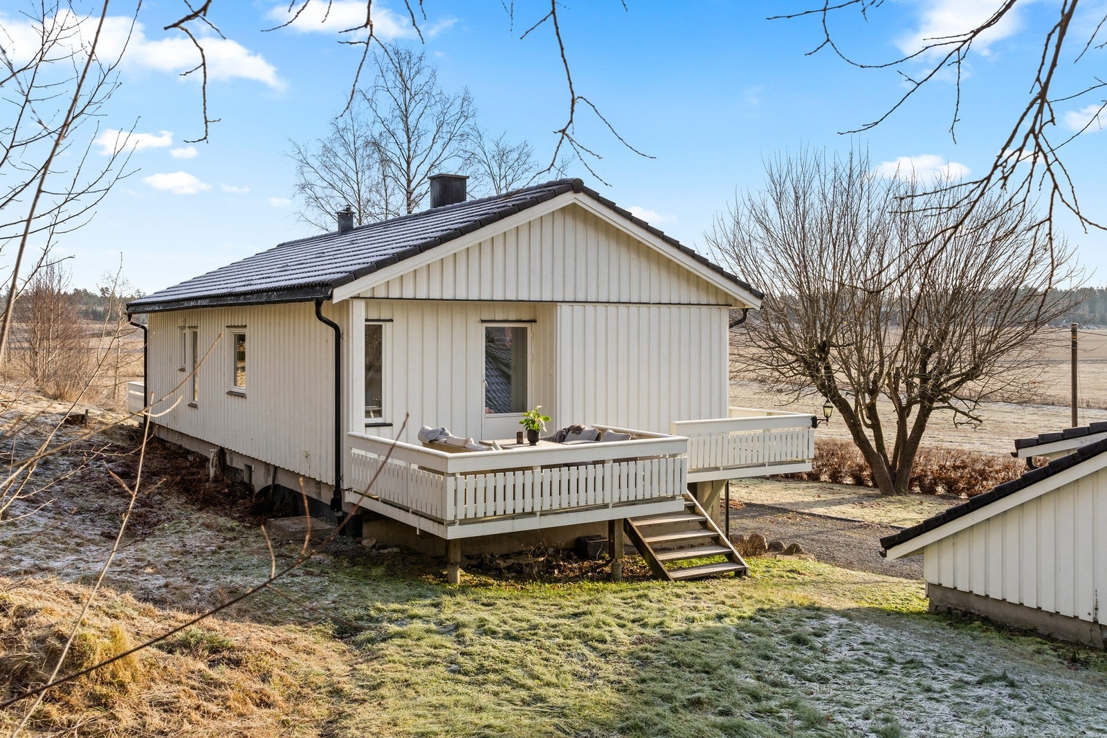 Boligen har en attraktiv plassering på tomten, omgitt av trær som gir både skjerming og en hyggelig atmosfære. Galleribilde