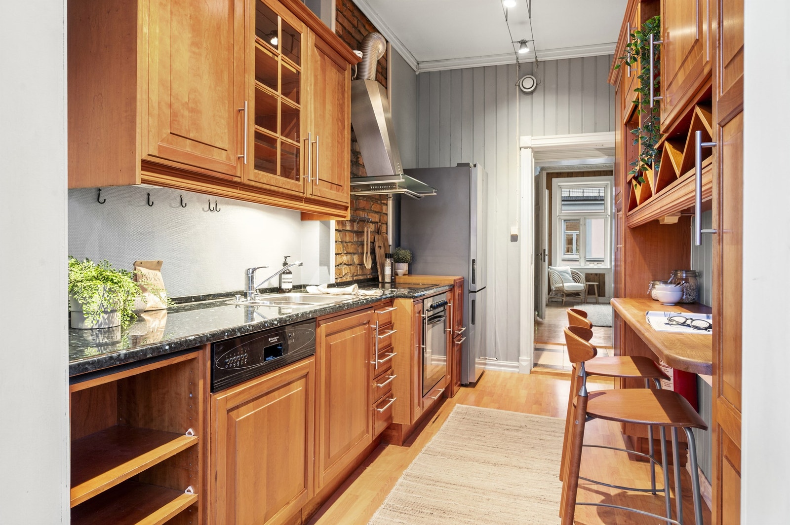 Kjøkkenet er fra år 2000 og består av profilerte skapdører og benkeplate av stein, samt benk i tre med integrert lys og barstoler. Galleribilde